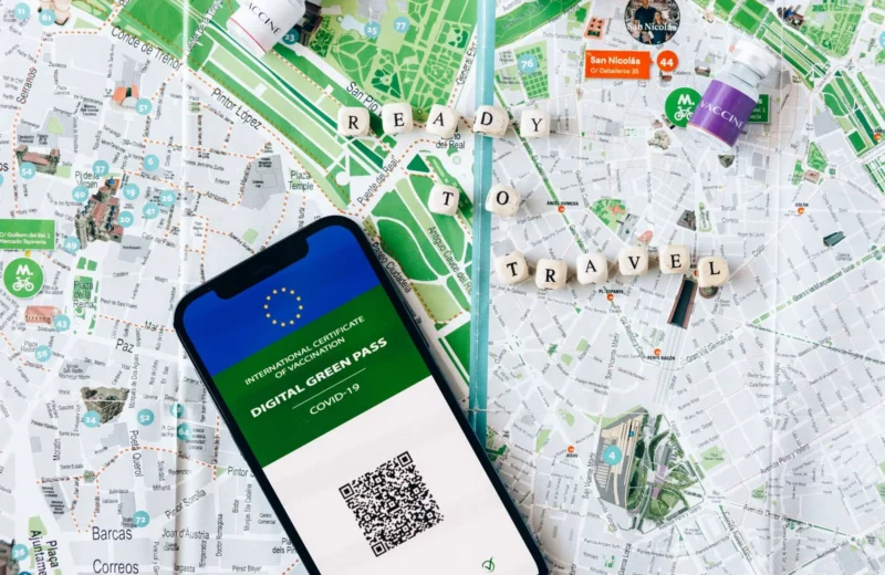 Digital Green Pass on phone with map background and travel concept.