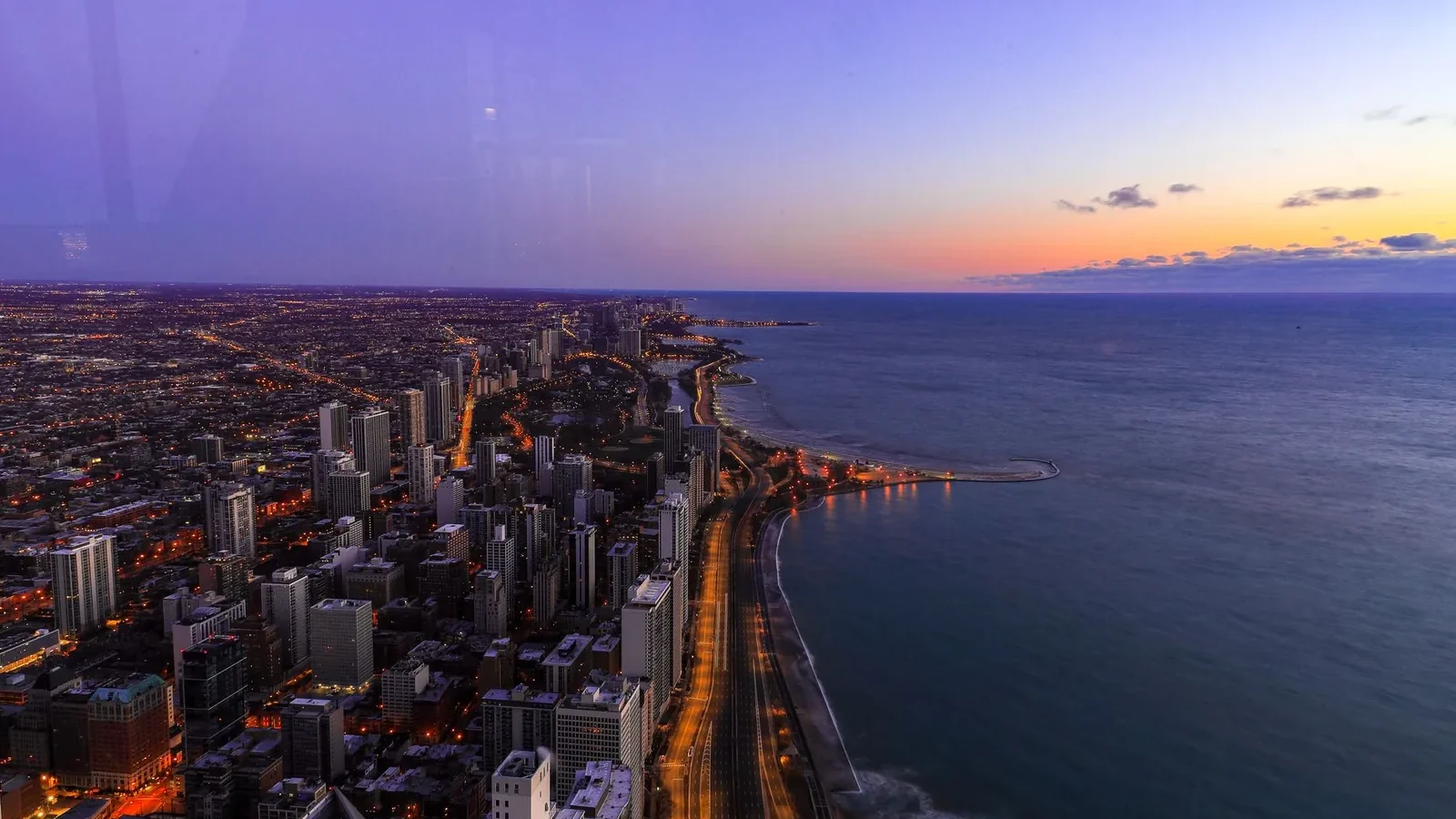 A breathtaking twilight cityscape overlooking the ocean, capturing vibrant urban lights.