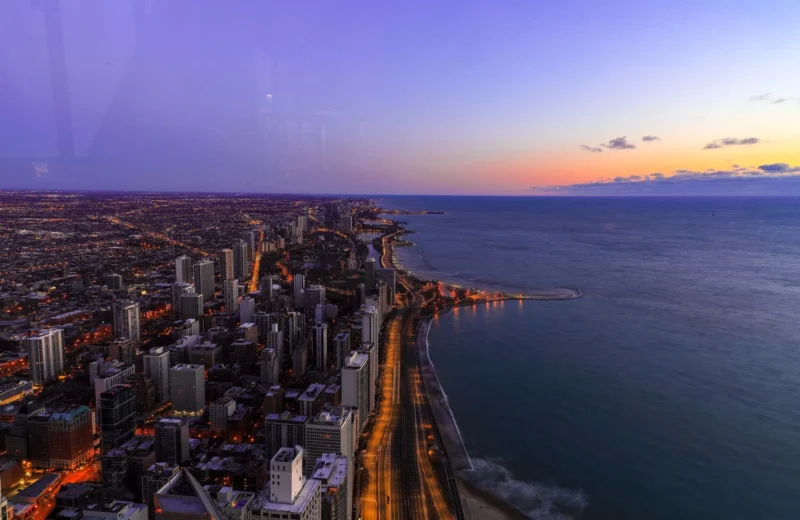 A breathtaking twilight cityscape overlooking the ocean, capturing vibrant urban lights.