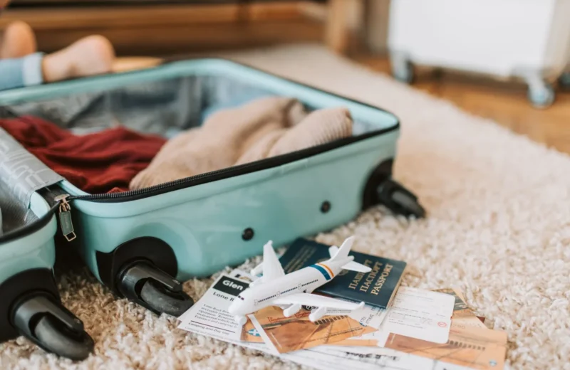 Close-up of an open suitcase with travel essentials like passport and tickets, ready for a journey.
