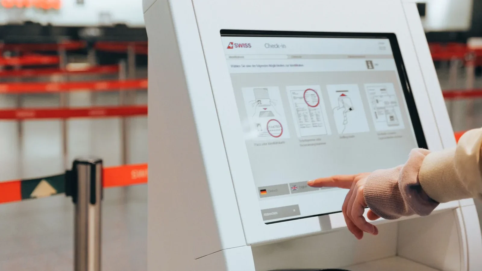Passenger using self-service check-in kiosk at airport for convenient travel experience.