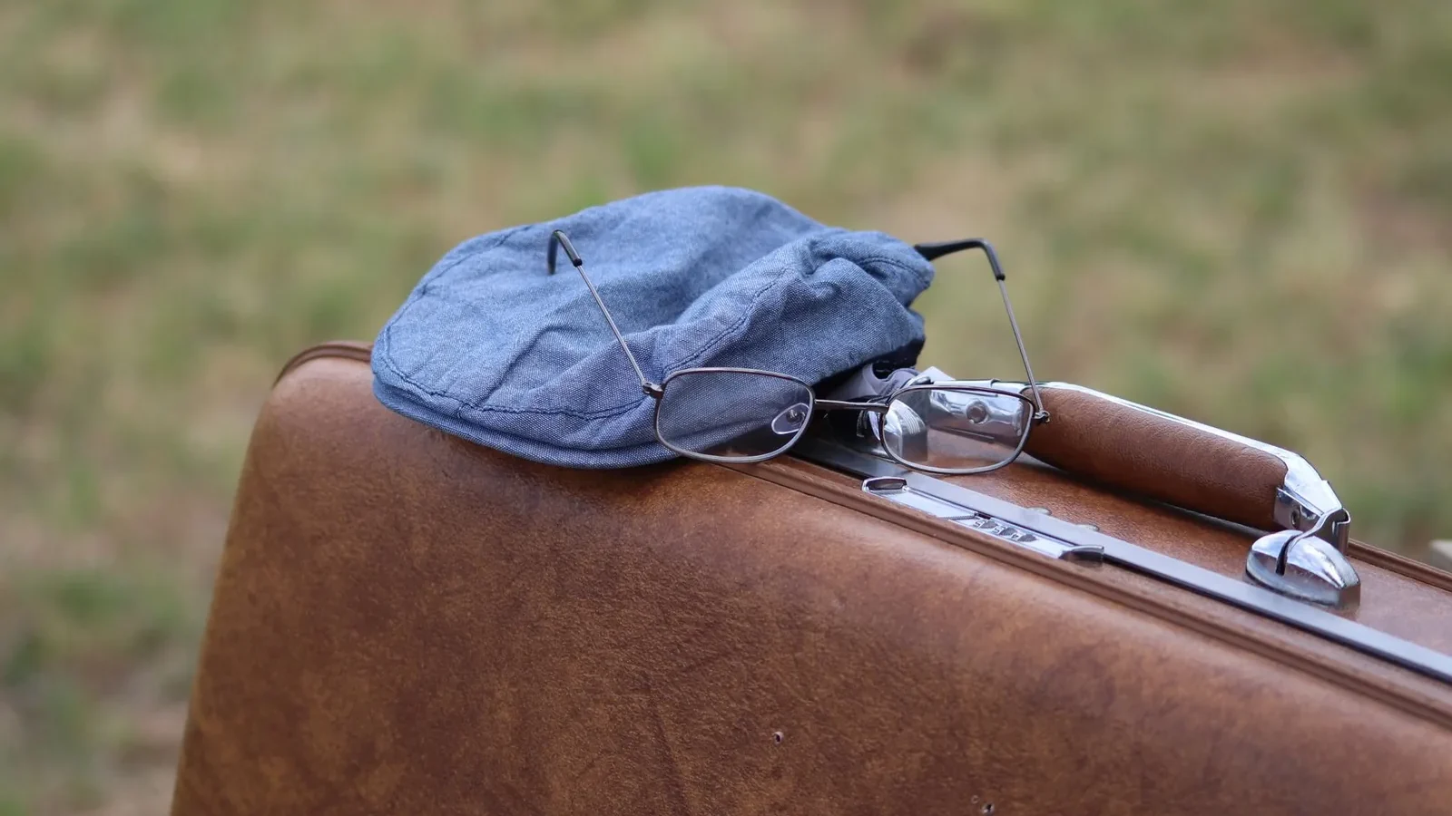 A classic scene featuring a vintage suitcase with a hat and glasses, evoking travel memories.