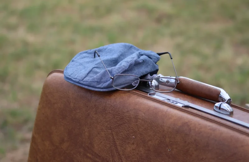 A classic scene featuring a vintage suitcase with a hat and glasses, evoking travel memories.