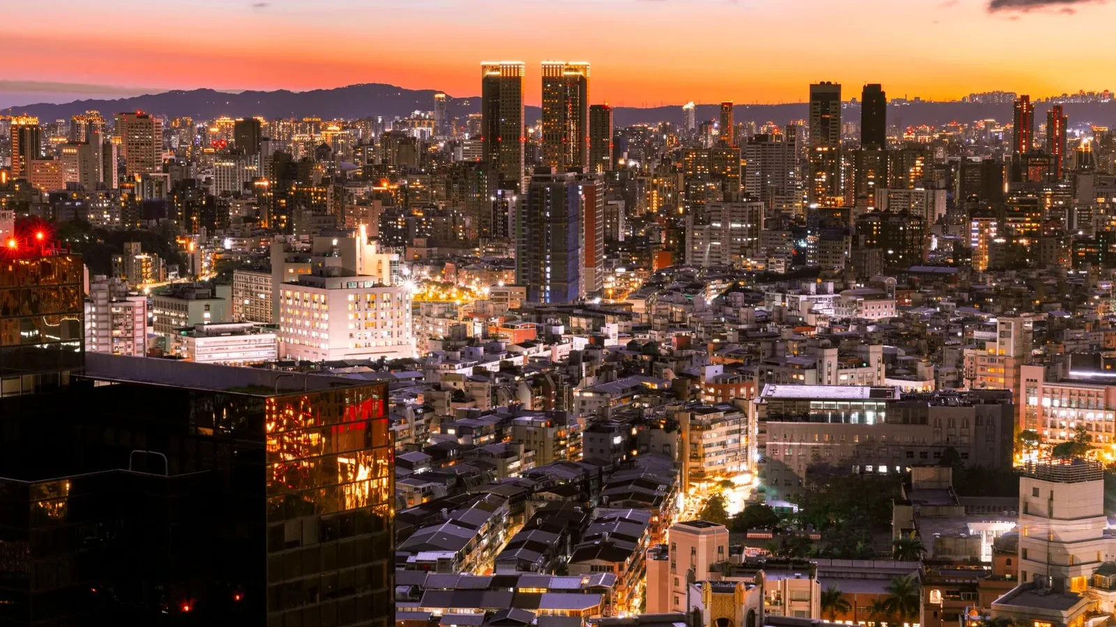 Vibrant twilight view of a modern cityscape with illuminated skyscrapers.