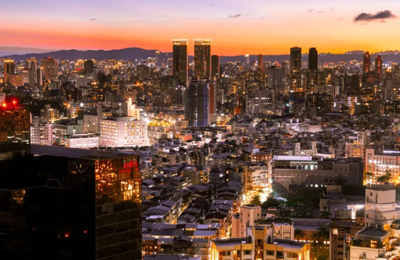 Vibrant twilight view of a modern cityscape with illuminated skyscrapers.