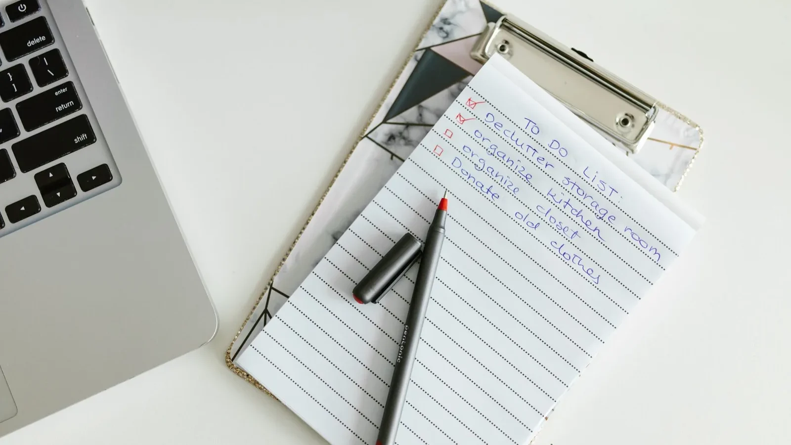 A neatly organized to-do list on a clipboard next to a laptop and pen, conveying productivity.
