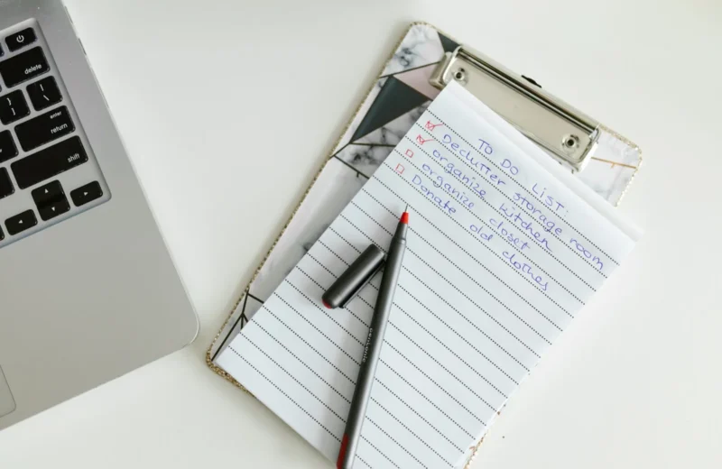 A neatly organized to-do list on a clipboard next to a laptop and pen, conveying productivity.