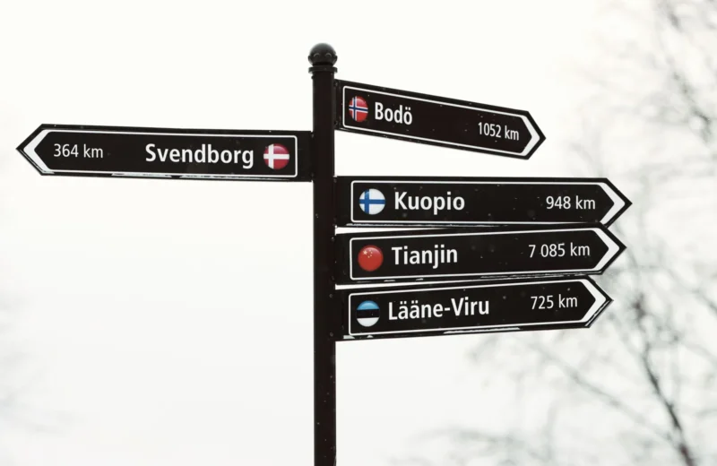 Snowy directional signpost showing distances to various cities from Jönköping, Sweden.