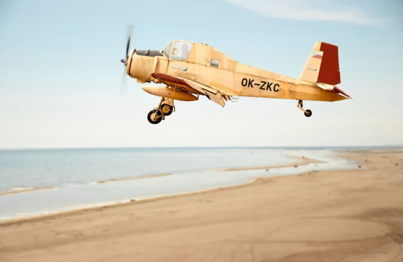 A vintage propeller plane flying low over the beach in Salacgrīva, Latvia.