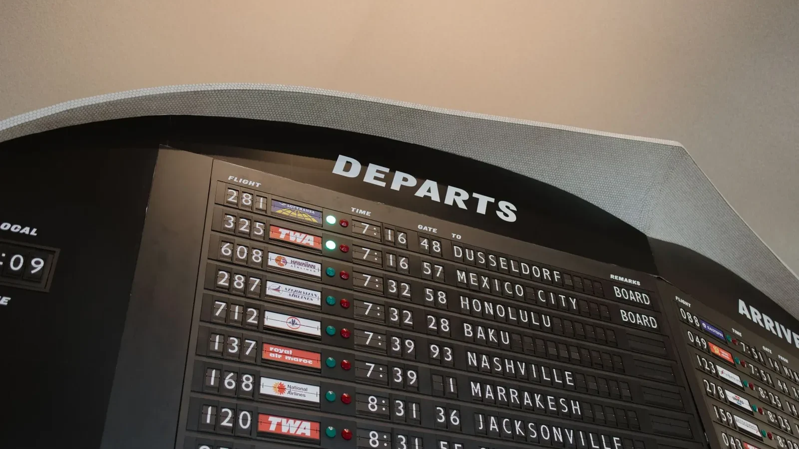 Close-up of airport departure board displaying flight details at JFK Airport, New York.