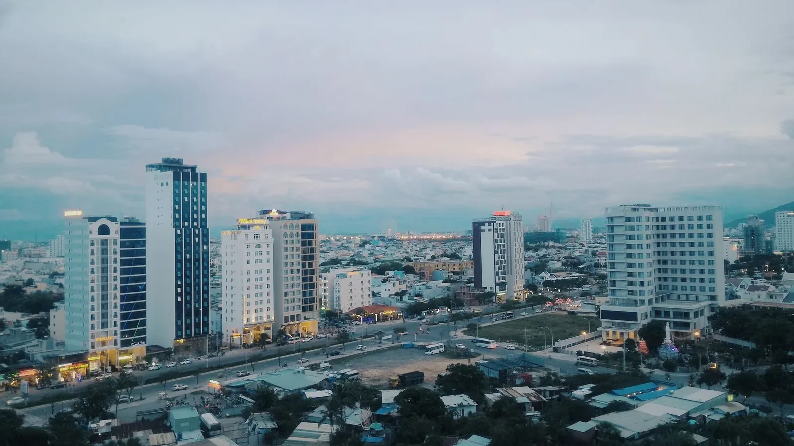 Stunning aerial view of a modern urban skyline with skyscrapers at dusk, capturing city lights and architecture.