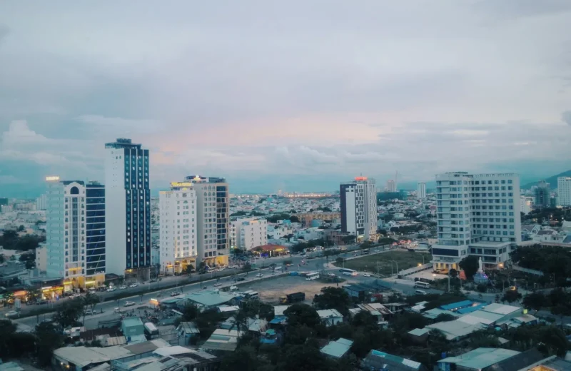 Stunning aerial view of a modern urban skyline with skyscrapers at dusk, capturing city lights and architecture.