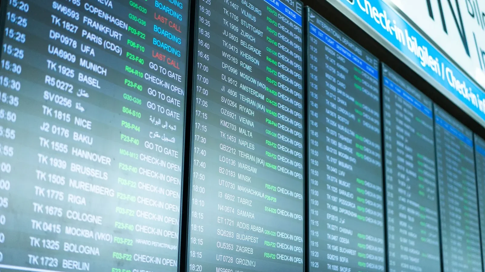 Digital screens display flight information and schedules at an airport terminal.