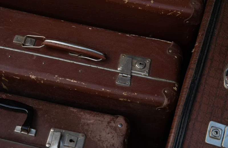 Detailed view of stacked vintage brown suitcases showcasing their classic design and wear.