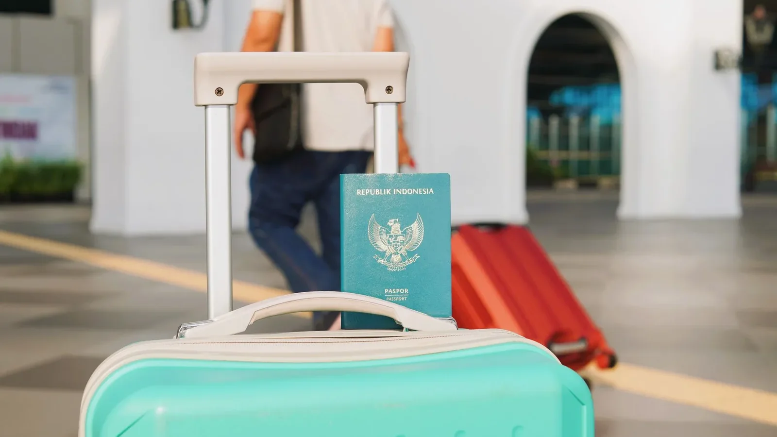 Traveler arrives at Yogyakarta airport, Indonesia with luggage and Indonesian passport in focus.