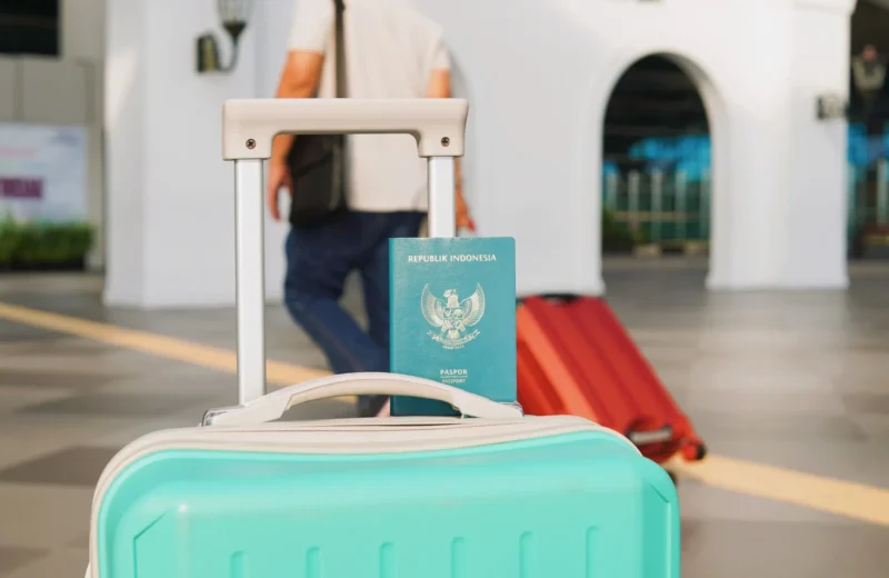 Traveler arrives at Yogyakarta airport, Indonesia with luggage and Indonesian passport in focus.