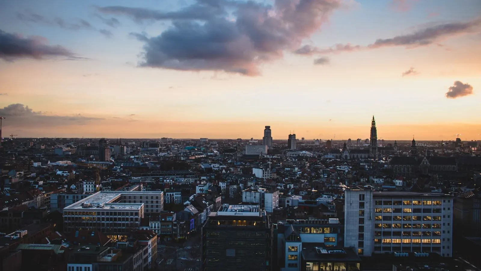 A stunning aerial view of Antwerp, Belgium, cityscape at dusk with vibrant sky colors.
