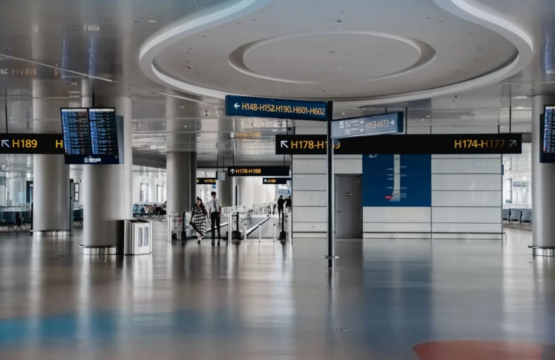 Spacious interior view of a modern airport terminal in Shanghai with signage and travelers.