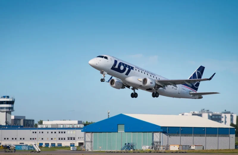 LOT Polish Airlines passenger jet taking off in clear blue skies from airport runway, showcasing aviation scene.