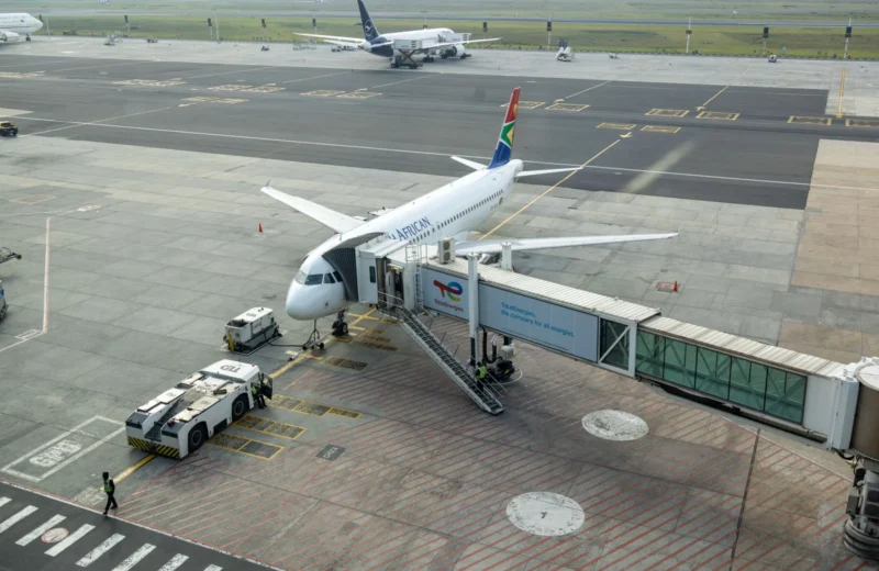 South African Airways plane docked at a gate in an airport, captured from an aerial view.
