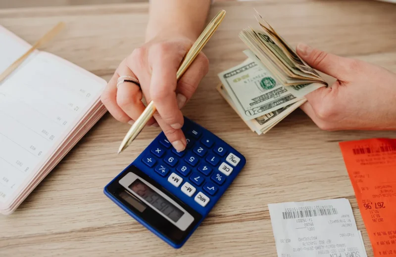 Hands handling cash and calculator for budget planning. Modern financial scene.