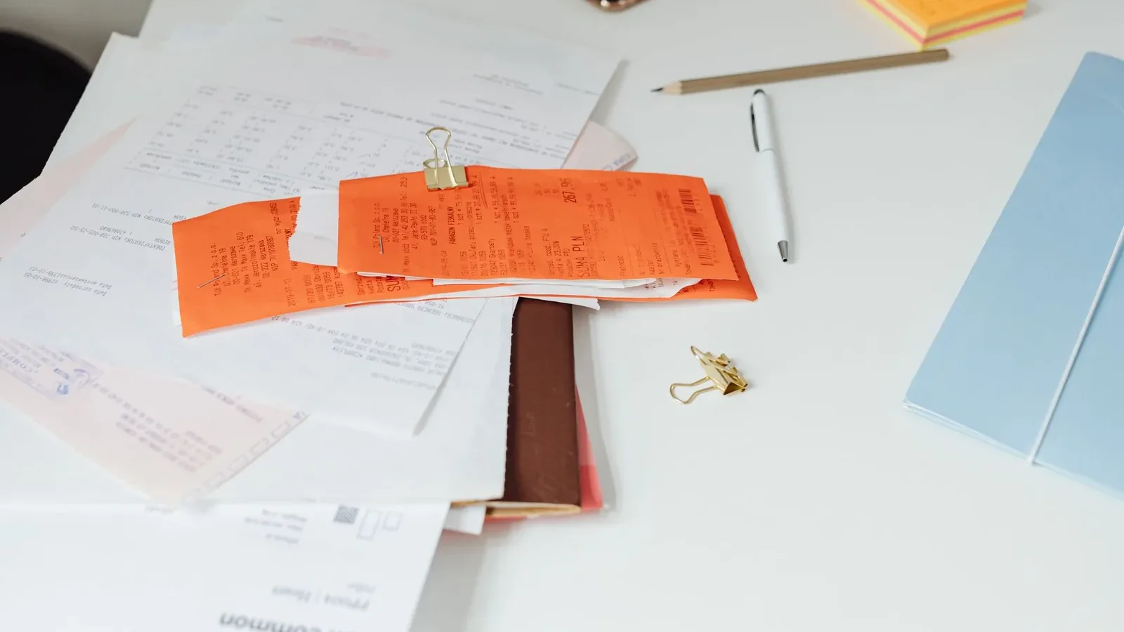 Close-up of a tidy desk with receipts, documents, and office stationery for business organization.
