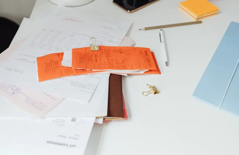 Close-up of a tidy desk with receipts, documents, and office stationery for business organization.