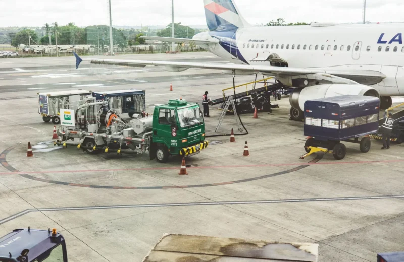 Ground support services in action at an airport terminal with visible aircraft and service vehicles.