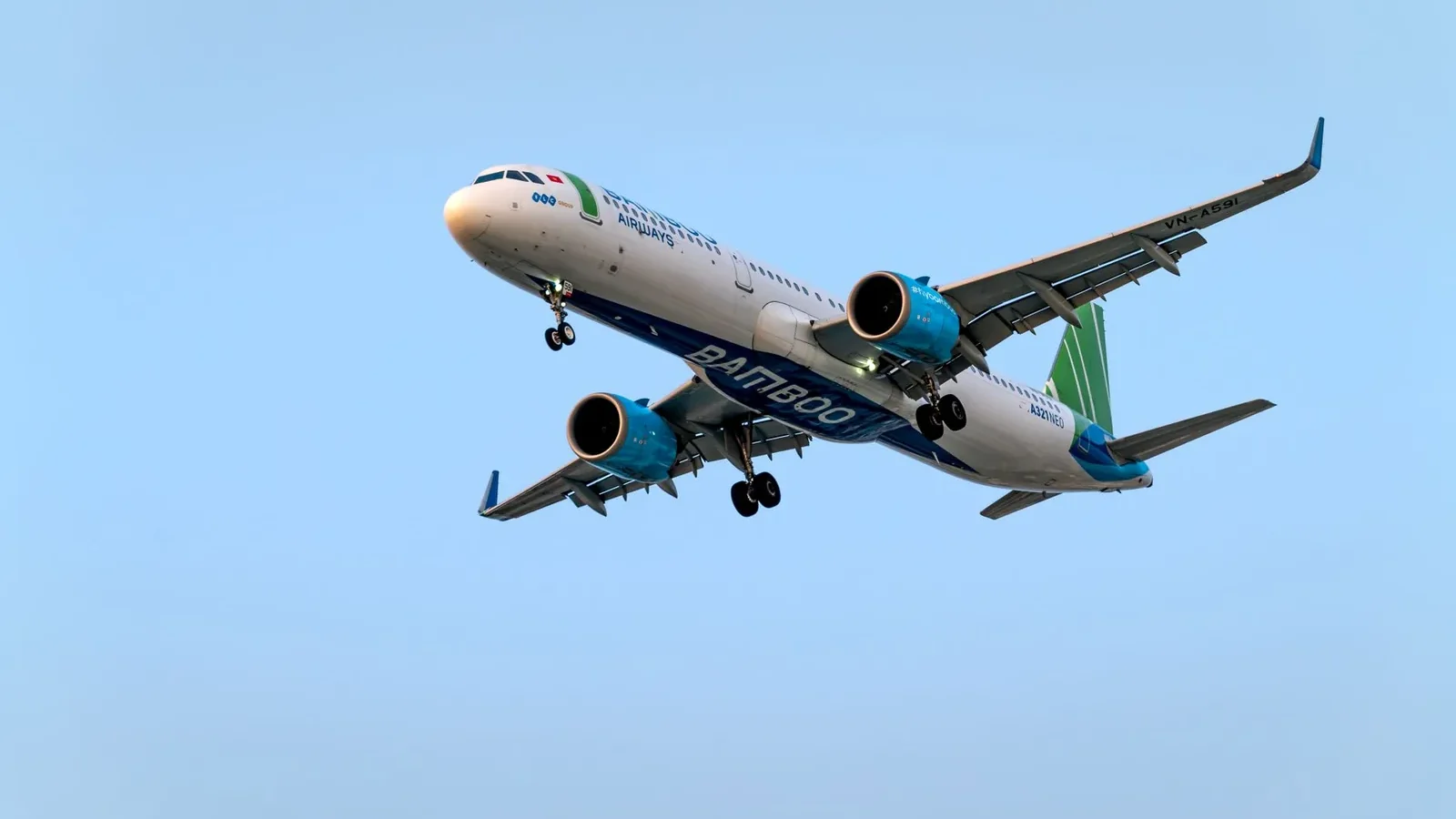 Low angle view of Bamboo Airways Airbus A321 flying against a blue sky.