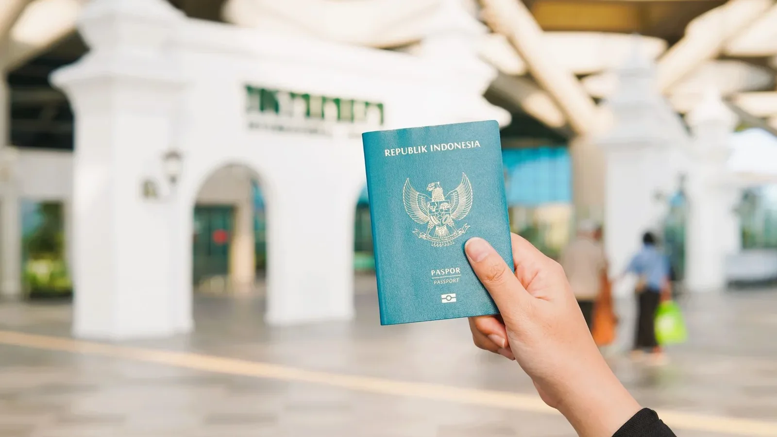 Close-up of a hand holding an Indonesian passport at Yogyakarta International Airport.