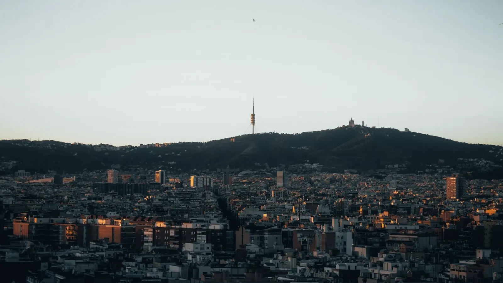Stunning view of Barcelona with Collserola Tower silhouetted against the evening sky.